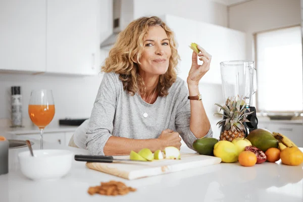 Foto colorida de mulher loira comendo frutas - Metrópoles