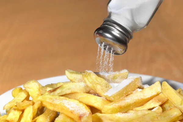 Foto colorida de batatas fritas com muito sal - Metrópoles.