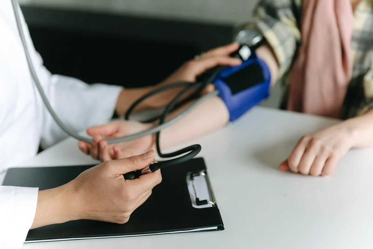 Mãos de médica medindo a pressão de paciente - Médicos apontam piores alimentos para quem tem pressão alta - Metrópoles