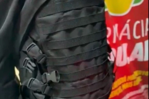Foto colorida de reprodução de vídeo mostrando suspeito de roubo à farmácia com colete balístico, nesta terça-feira (24/3), na zona sul de São Paulo.