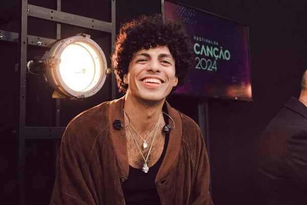 foto colorida de homem negro de pele clara com cabelos cacheados sorrindo - metrópoles
