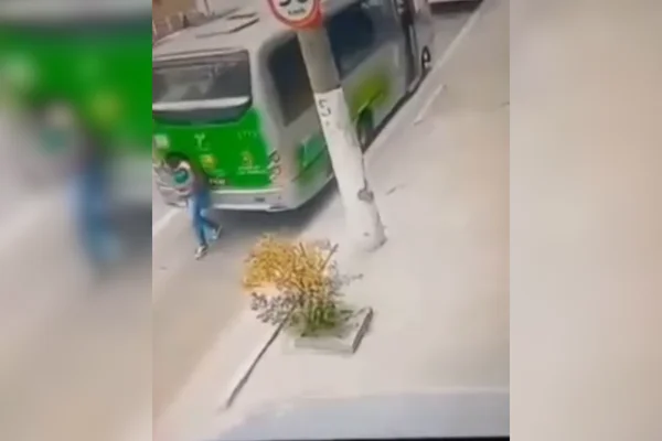 Imagem colorida de um ônibus em marcha à ré atropelando uma mulher - Metrópoles