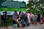 Passageiros fazem fila para pegar táxi após travessia de barco pelo Rio Curuçá