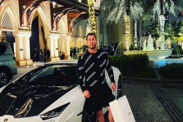 Homem encostado em carro de luxo influenciador - Metrópoles