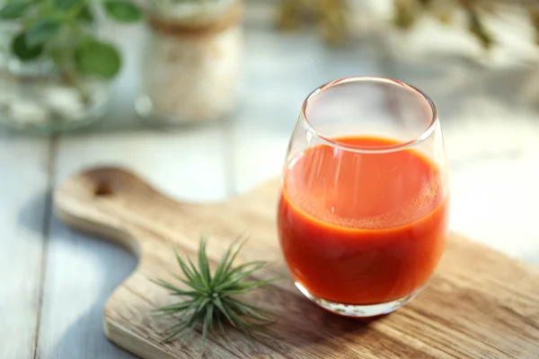 Imagem mostra copo de suco vermelho em cima de uma tábua de madeira - Metrópoles