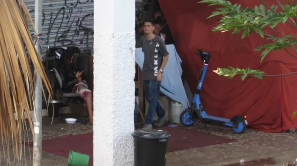 homem ao lado de patinete elétrico