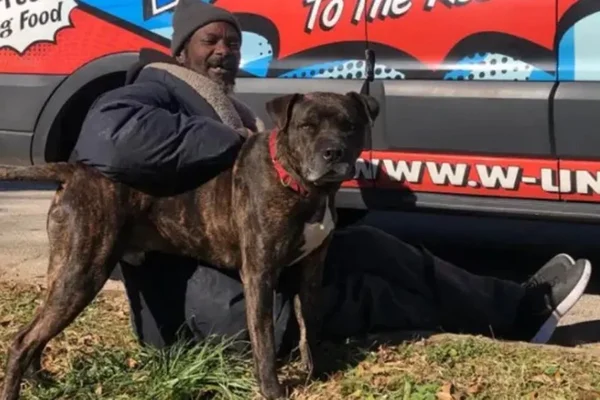 Na imagem colorida, um homem em situação de rua posa ao lado de um cachorro - Metrópoles