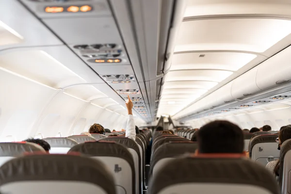 Na imagem colorida, uma pessoa pede ajuda em um assento de avião - Metrópoles