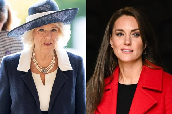 Do lado esquerdo tem a rainha consorte Camilla de blaser azul. Do lado direto, Kate com cabelos soltos e lisos em um traje vermelho - Metrópoles