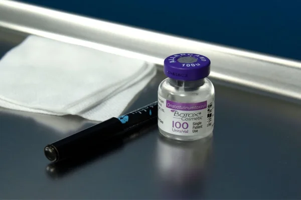 um vidro de botox com uma caneta ao lado