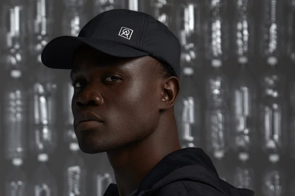 Na imagem com cor, modelo negro usa boné preto da Oriba - Metrópoles