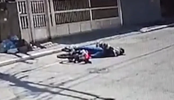 Em foto colorida jovem caído na rua ao lado de moto - Metrópoles