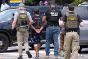 Oficiais do Departamento de Segurança Interna (HSI), o braço investigativo do Departamento de Segurança Interna dos EUA (DHS), e policiais da Polícia de Parques dos EUA detêm uma pessoa no National Mall