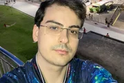 Dudu Camargo posa de óculos e camiseta azul