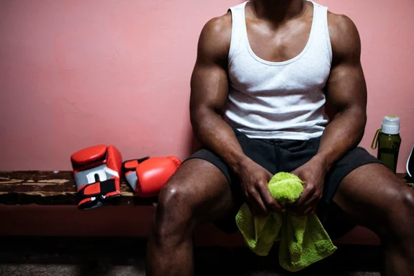 Foto colorida de homem musculoso sentado em banco - Metrópoles