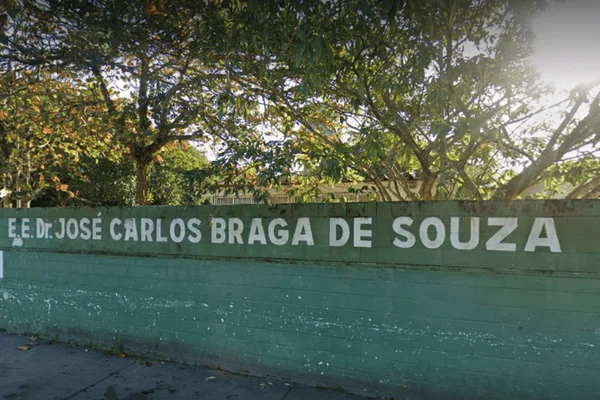 Imagem colorida de um muro verde de uma escola estadual de Itanhaém - Metrópoles