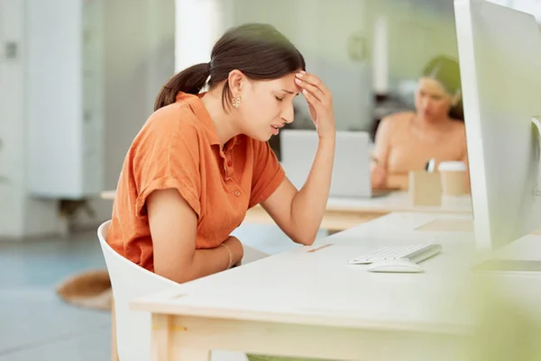 Mulher com mão na barriga em frente a computador - Metrópoles - Saúde mental no trabalho