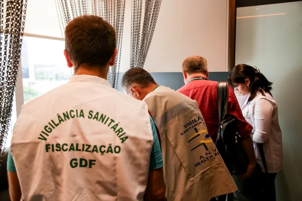 Imagem colorida de um homem vestindo um colete da Vigilância Sanitária do DF