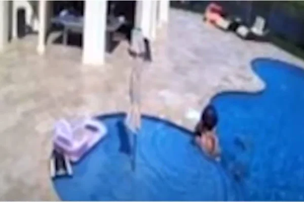 Imagem colorida mostra momento em que criança resgatou homem que se afogava em piscina - Metrópoles