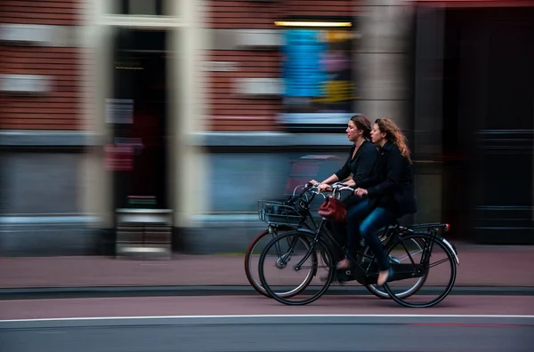 mulheres andando de bicicleta em uma ciclovia