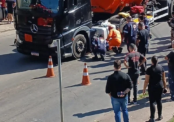 pessoas vendo jovem debaixo de carreta em JF