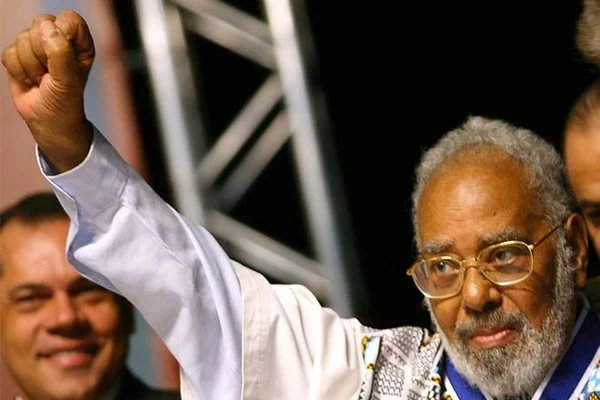 Imagem colorida mostra o professor Abdias Nascimento, um homem negro, grisalho, usando uma camisa branca e óculos de grau - Metrópoles
