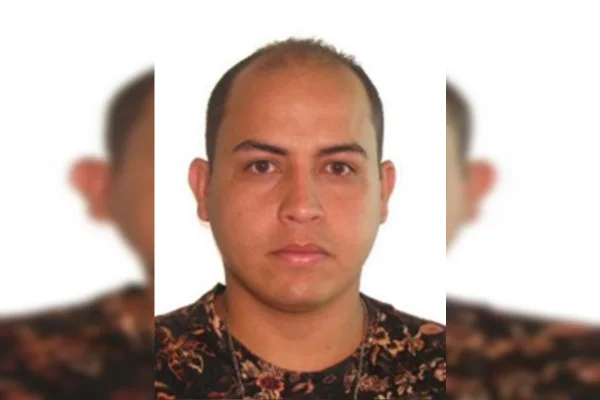 Foto 3x4 de um homem branco, calvo, que veste camiseta florida escura