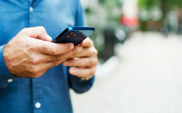 Foto colorida de homem branco segurando celular - Metrópoles