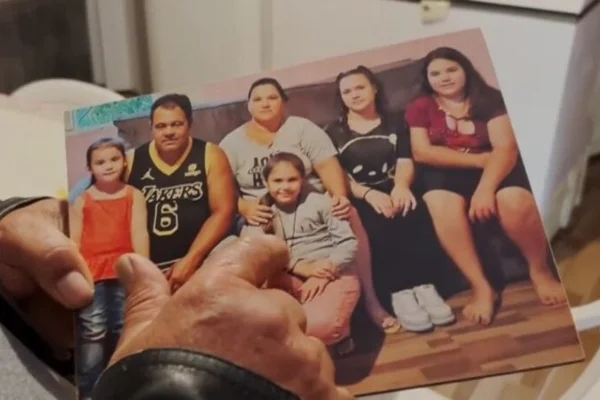 Foto colorida de menina que passou por cirurgia após ser atingida por uma trave de futsal, junto com a família