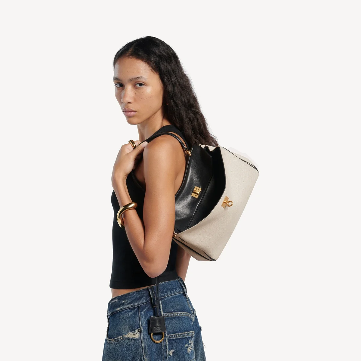 Bolsa em lona de linho bege natural e pele de cordeiro curtida vegetalmente na cor preta, com detalhes metálicos em tom de ouro envelhecido Bolsa em lona de linho bege natural e pele de cordeiro curtida vegetalmente na cor preta, com detalhes metálicos em tom de ouro envelhecido
