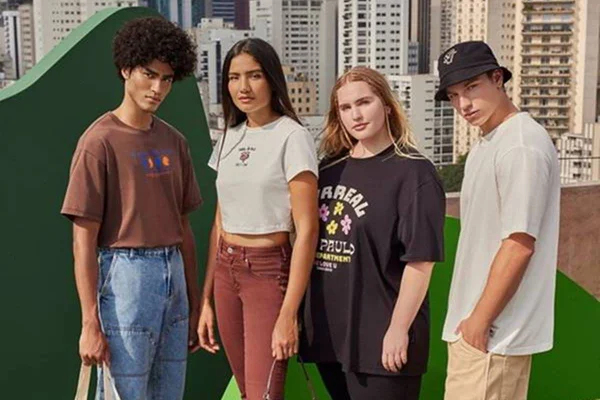 Quatro modelos, uma negra com camiseta marrom, uma com camiseta branca, uma com camiseta preta e um com camiseta branca e calça cargo