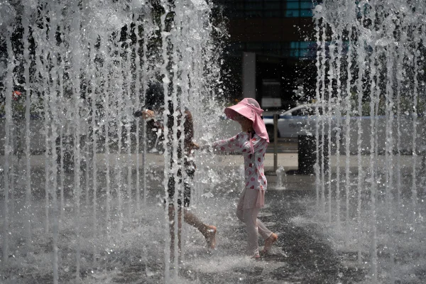 Crianças brincam na Fonte de Gwanghwamun enquanto é emitido um alerta de onda de calor intensa, em meio à onda de calor que atinge Seul, Coreia do Sul