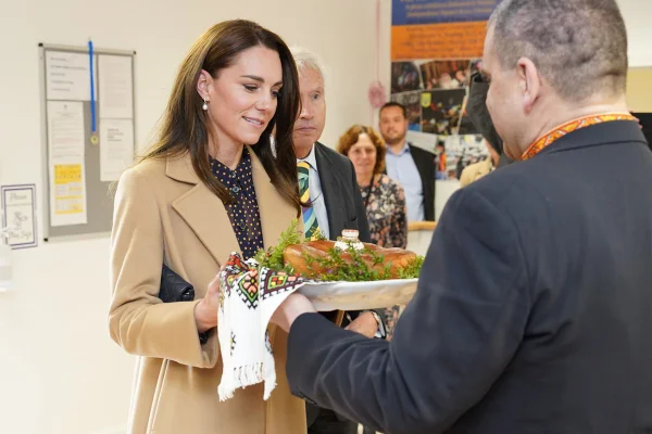 Foto colorida de mulher segurando bandeja com delícia. Ela recebe o alimento de um homem - Metrópoles