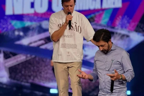 Pastor André Valadão abençoa, com a mão direita, o prefeito Ricardo Nunes, ajoelhado