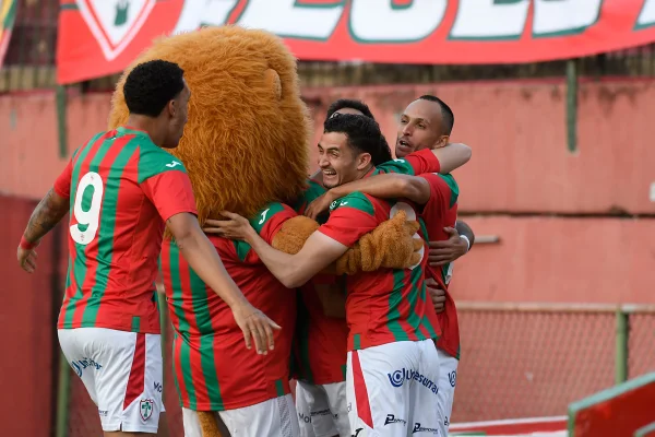 Jogadores da Portuguesa de São Paulo comemoram gol com o mascote Leão