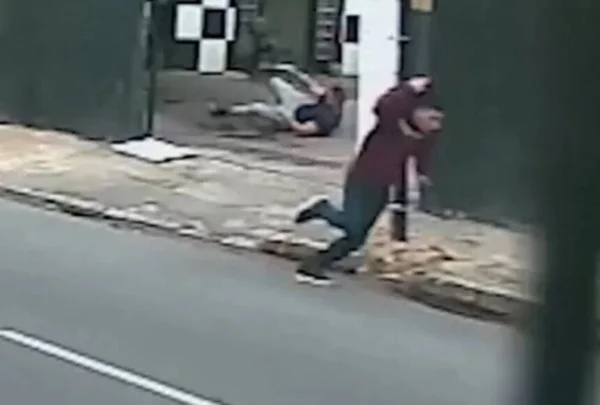 Em foto ccolorida ladrão de camiseta vinho e calça jeans escura corre em frente a lava rádpido - Metrópoles