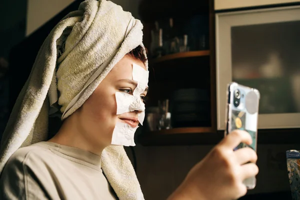 Adolescente faz skincare se olhando em tela de celular - Metrópoles