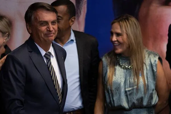 Fotografia colorida de homem de terno ao lado de mulher de azul que sorri