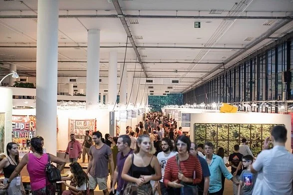 Multidão caminha em feira de arte