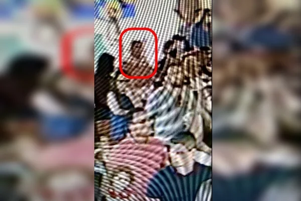 Print de filmagem de câmera de segurança com destaque em vermelho ao redor de mulher