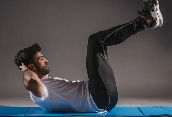Homem deitado no chão fazendo abdominais