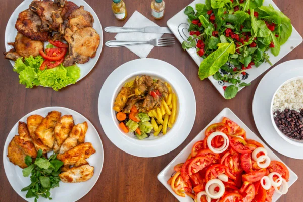 Imagem colorida de mesa com diferentes porções e comidas