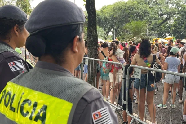 Imagem colorida mostra policiais militares durante bloco de carnaval. Metrópoles