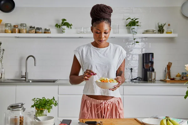mulher colocando alimentos cortados em um bowl