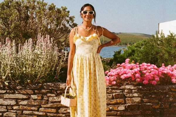 Na imagem com cor, uma mulher posando para foto com um vestido fresco floral para o verão - Metrópoles