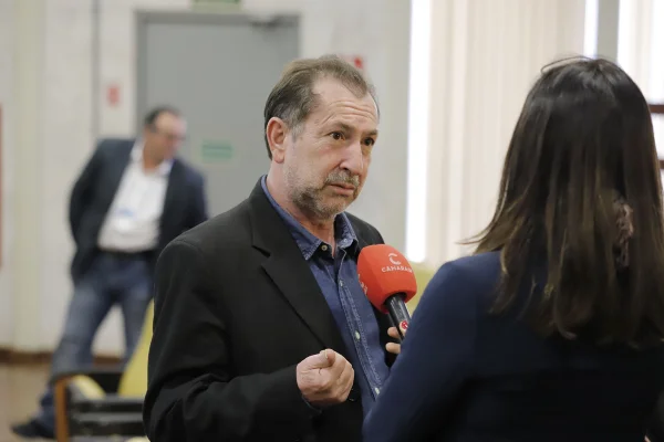 Imagem colorida mostra jair tatto, homem branco de cabelos claros, vestindo terno escuro e camisa jeans, dando uma entrevista - Metrópoles
