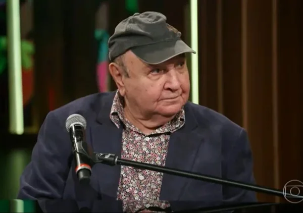 João Donato de boné e microfone em frente em programa da Globo