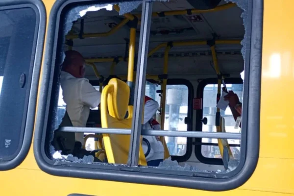 Imagem colorida mostra janela de ônibus quebrada após ataque - Metrópoles