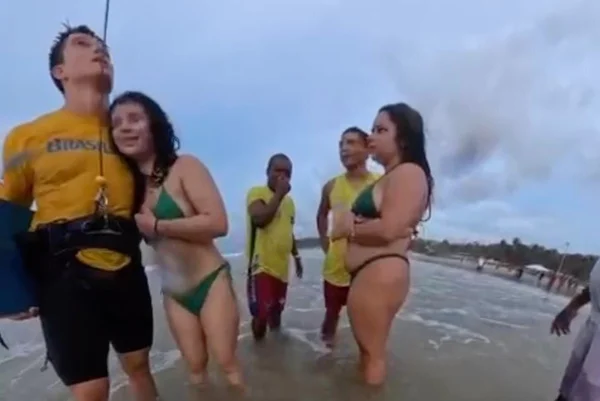 Foto colorida do kitesurfista Bruno Lobo resgatando jovem - Metrópoles