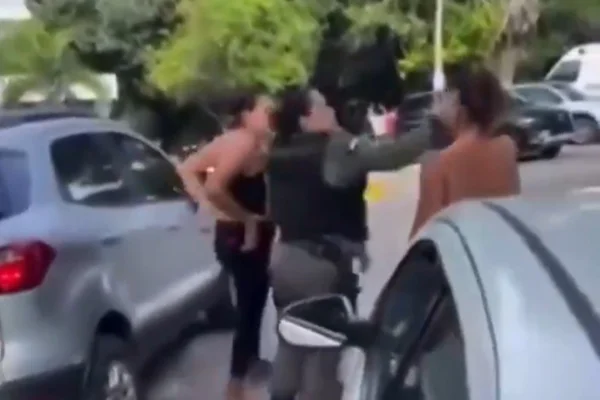 Imagem colorida mostra trecho de vídeo em que PM dá tapa no rosto de suspeita de agredir filha - Metrópoles